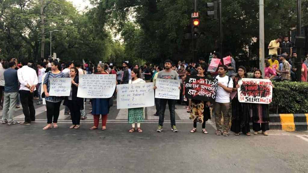 Protesters hold placards in solidarity in Delhi on Sunday, 15 April.&nbsp;