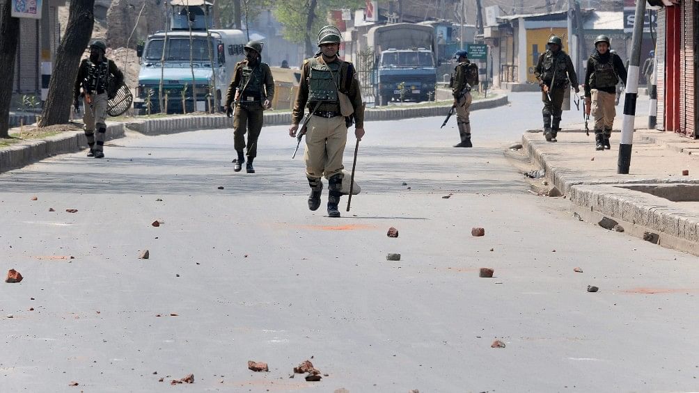 Security personnel patrol a street in Srinagar on 1 April during restrictions imposed after clashes erupted following the killing of eight militants and two civilians in Shopian encounters.&nbsp;