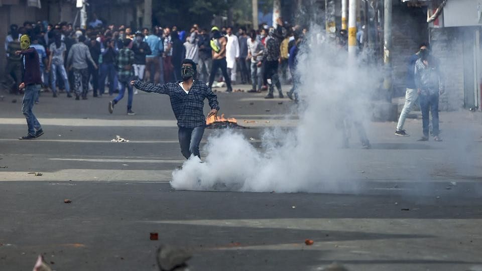 People throw stones at security forces during a protest against the recent Shopian killings, in Srinagar on 6 April.