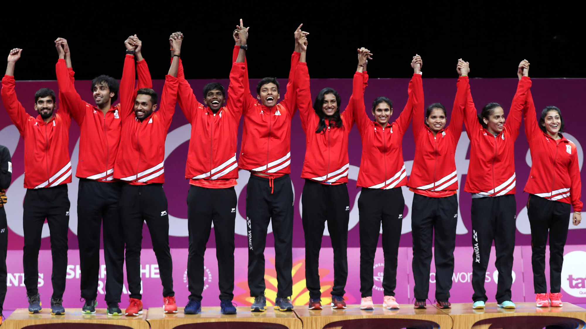 The Indian mixed badminton team on the victory podium after winning the gold.