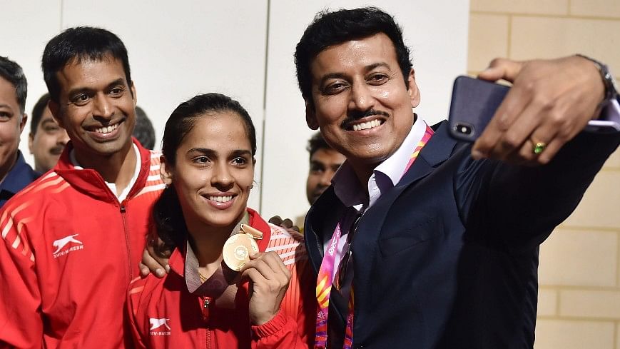 P Gopichand (left) poses with Gold Medalist Saina Nehwal (centre) and Sports Minister Rajyavardhan Rathore (left) after Saina Nehwal’s gold medal win against teammate PV Sindhu.