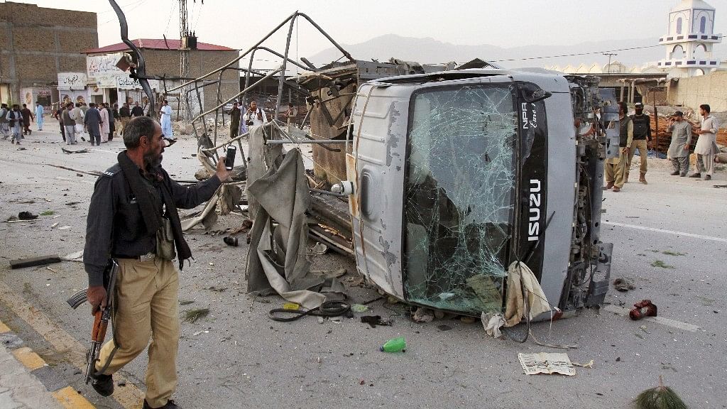 A Pakistani police officer walks past a police vehicle targeted by a suicide bomber in Quetta, Pakistan on 24 April 2018.&nbsp;
