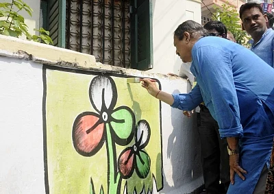 Kolkata: West Bengal Panchayat Minister and Trinamool Congress leader Subrata Mukherjee paints a graffiti ahead of legislative polls in Ekdalia of Kolkata on March 5, 2016. 
