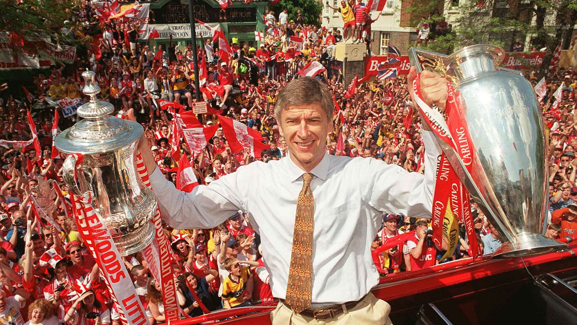 17 May 1998: Arsenal’s French manager Arsene Wenger holds both the League and the FA Cup trophies at a victory parade in London May 17.&nbsp;
