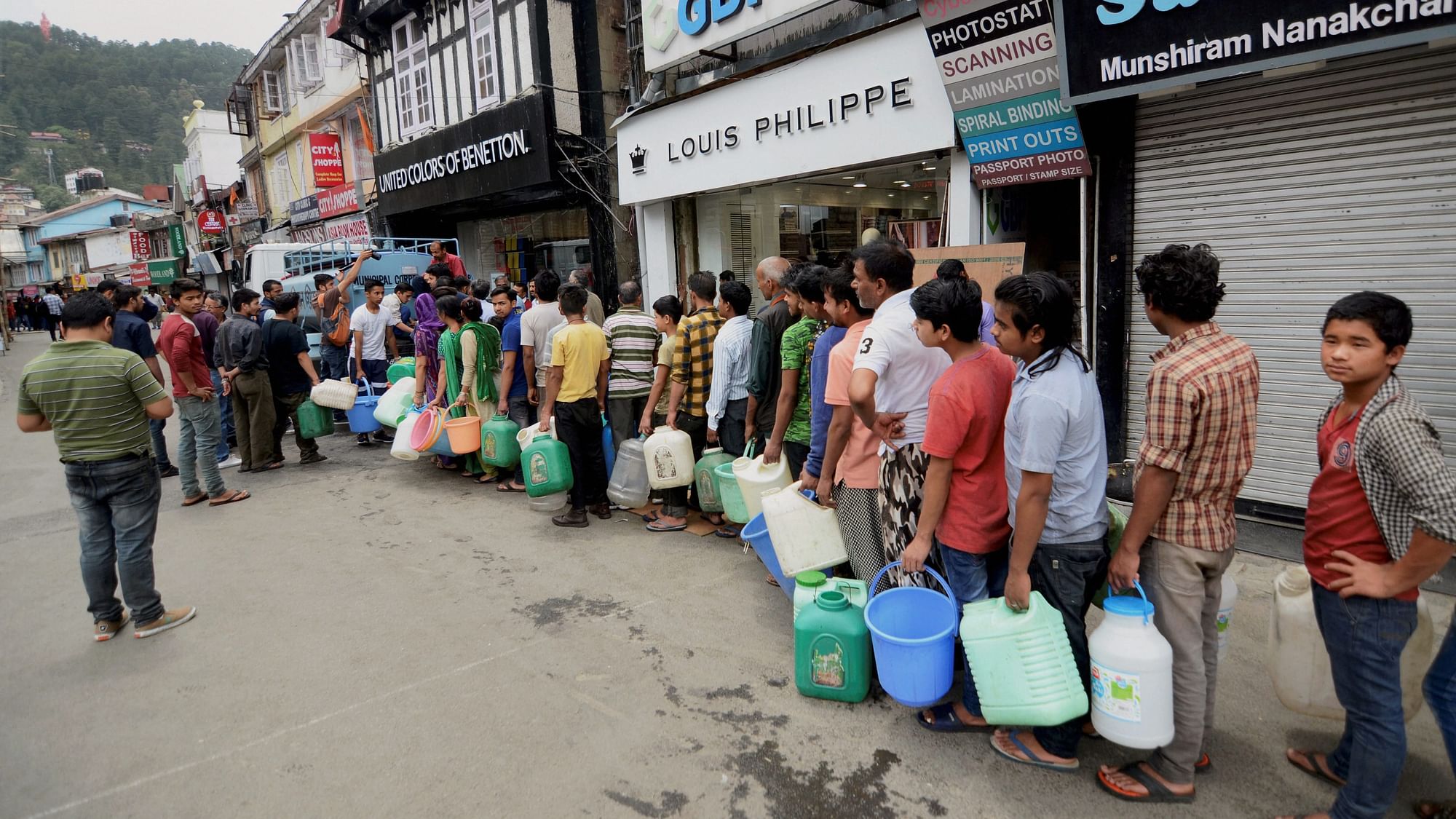 People stand in a queue to collect water from a tanker, as Shimla faces acute shortage of drinking water. Image used for representation.