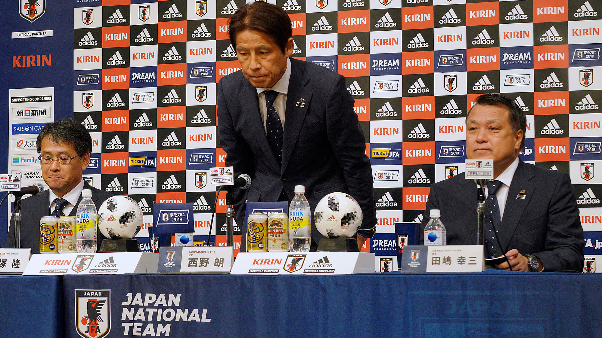 Japanese men’s national soccer coach Akira Nishino, centre, bows at the start of a press conference to announce Japanese squad members for the World Cup.
