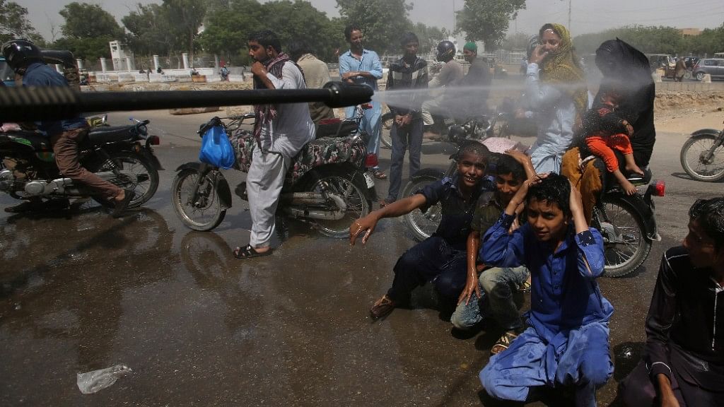 Pakistani volunteer spray water on people to keep them cool as temperatures reached 43 degrees Celsius in Karachi.&nbsp;