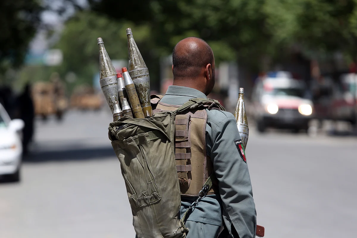 An Afghan security personnel stands at the site of a suicide attack, in the center of Kabul, Afghanistan.