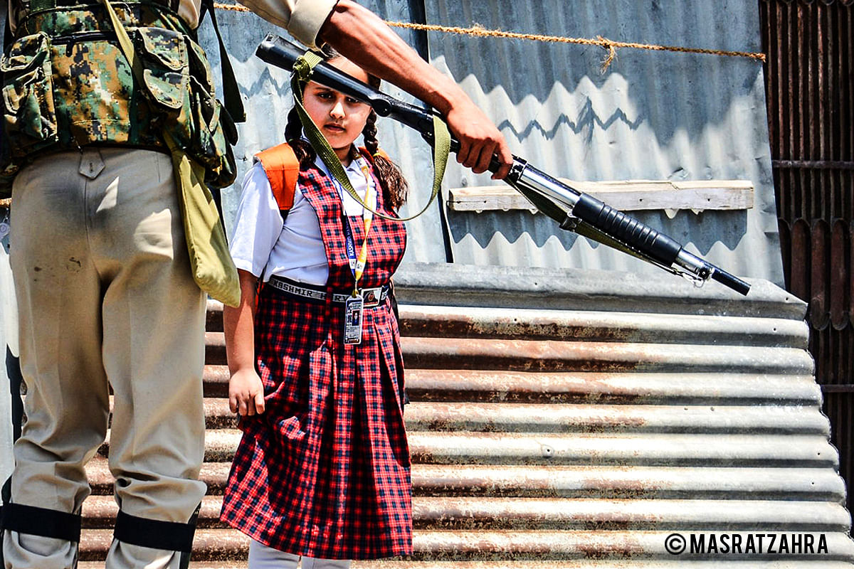 A girl in uniform looks at the pellet gun during a curfew in Old Srinagar on 28 July 2017.