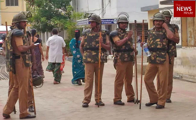 Police stand guard to jump into action in the event of violence