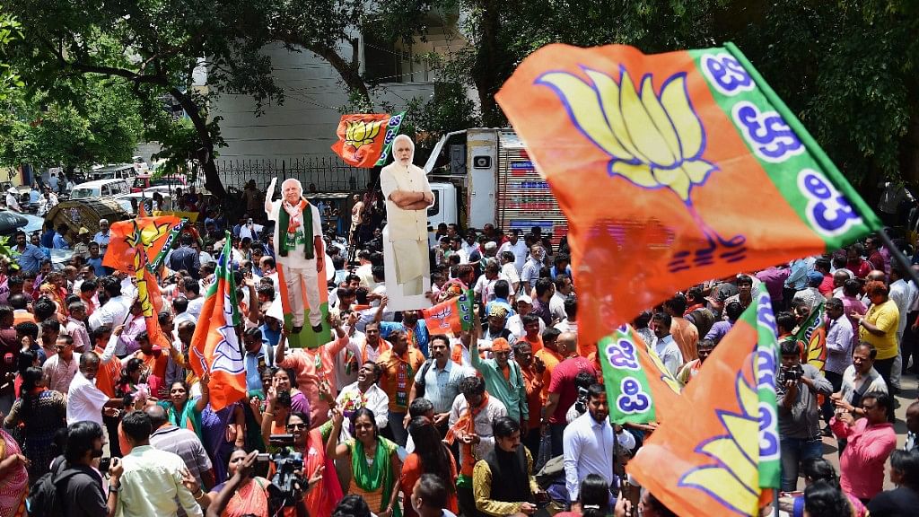 BJP workers celebrate the party’s lead on more than 100 Assembly seats as the counting of votes is in progress, outside the party office in Bengaluru.&nbsp;