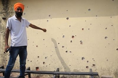 Jammu: A man shows a wall damaged in cross border firing in RS Pura of Jammu and Kashmir on May 18, 2018. (Photo: IANS)