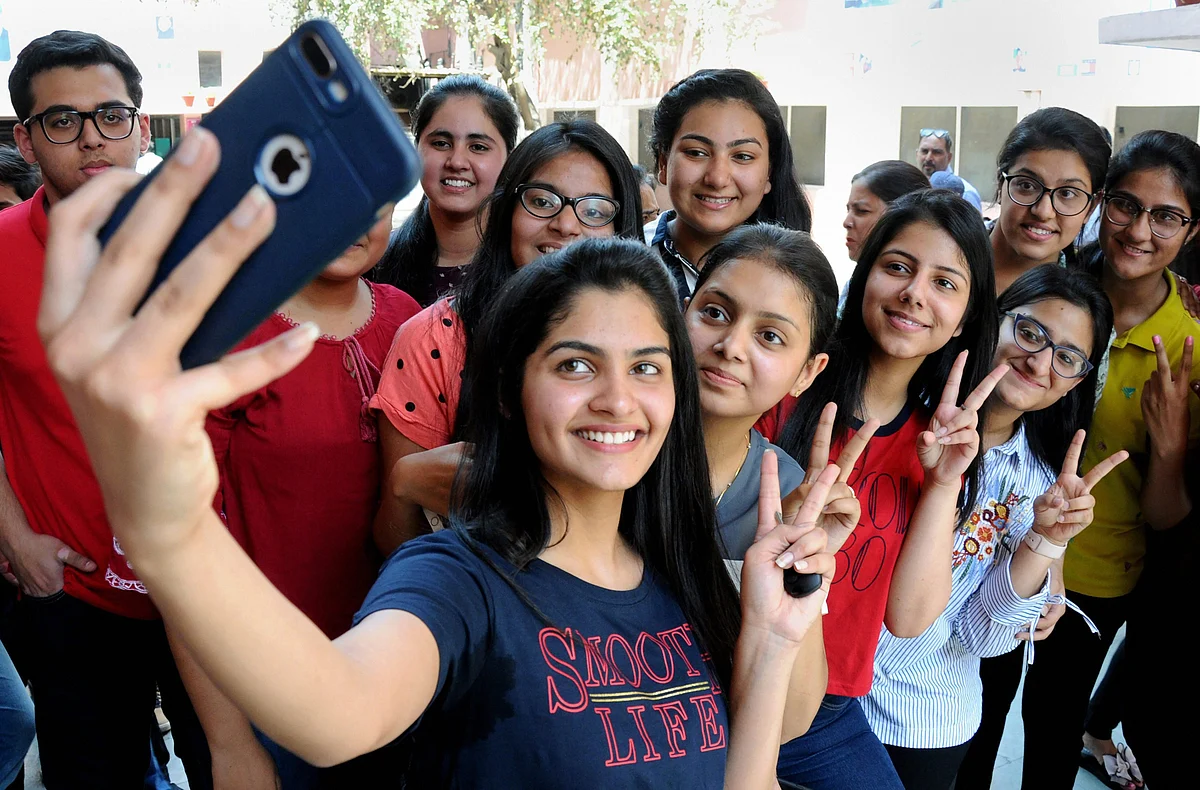 Students take selfies as they celebrate at St. Thomas school in New Delhi on Saturday.