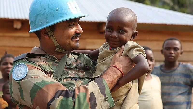 An Indian peacekeeper with a child in Congo.