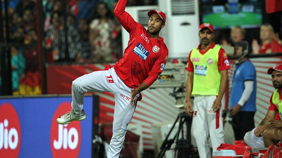 Mayank Agarwal throws the ball to Manoj Tiwary before going over the boundary rope.
