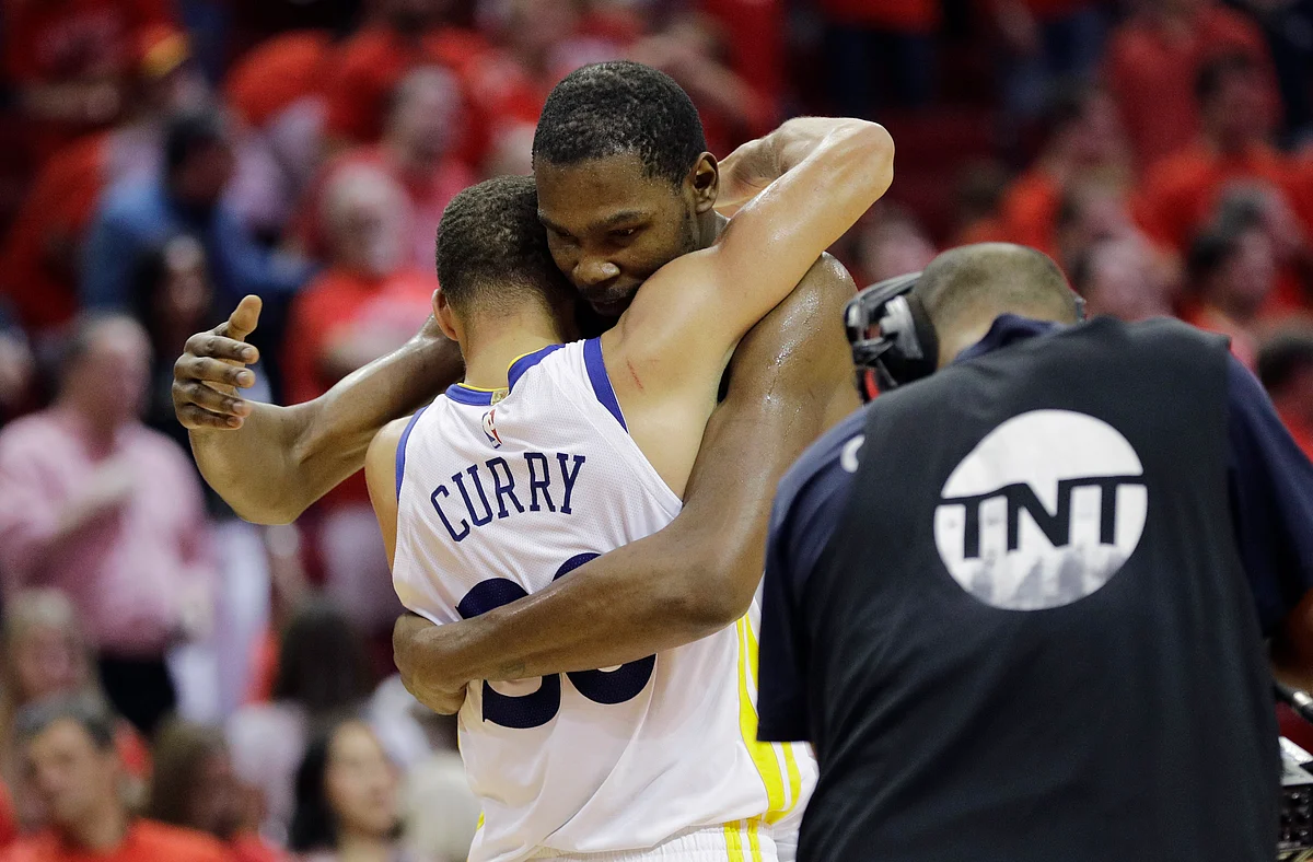 Golden State Warriors forward Kevin Durant, right, hugs teammate Stephen Curry, left, after they defeated the Houston Rockets in Game 7 of the NBA basketball Western Conference finals, Monday, May 28, 2018, in Houston.