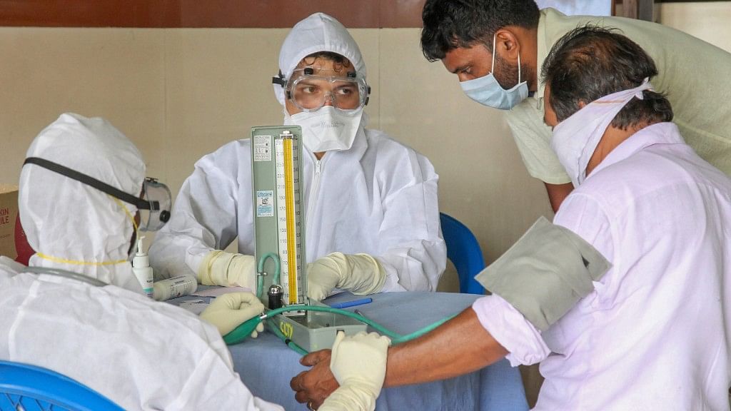 Doctors and patients wear safety masks at a Medical college in Kozhikode.