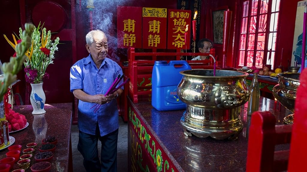 An elderly Chinese-Indian man offers prayer at a Chinese temple of Guan Yu, the traditional god of war, in Kolkata. The Chinese-Indians – Buddhists and Christians – regularly visit temples of Chinese gods and goddesses.