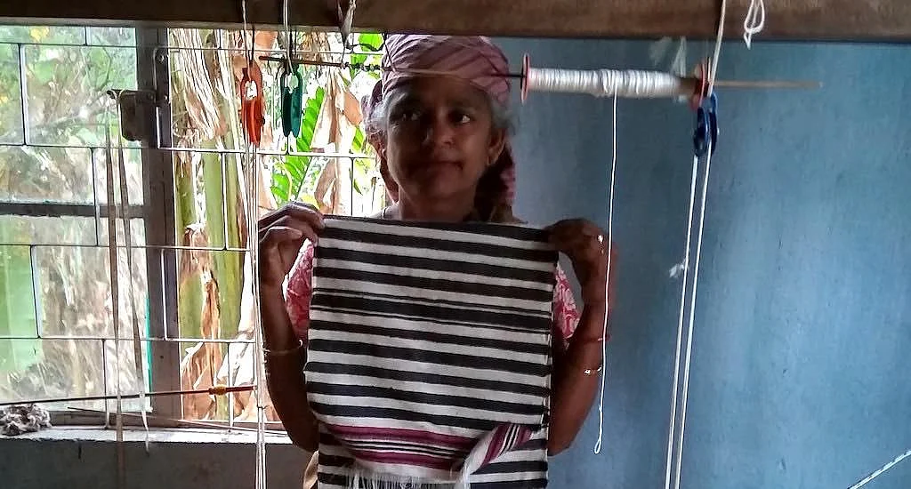 A Bhoi woman displays a just woven stole in the Diwon workshop.