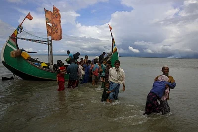 Dakhinpara: Rohingya refugees arrive at Shah Porir Dwip in Dakhinpara ofBangladesh from Rasidong in Myanmar, on Sept 13, 2017. (Photo: bdnews24/IANS)