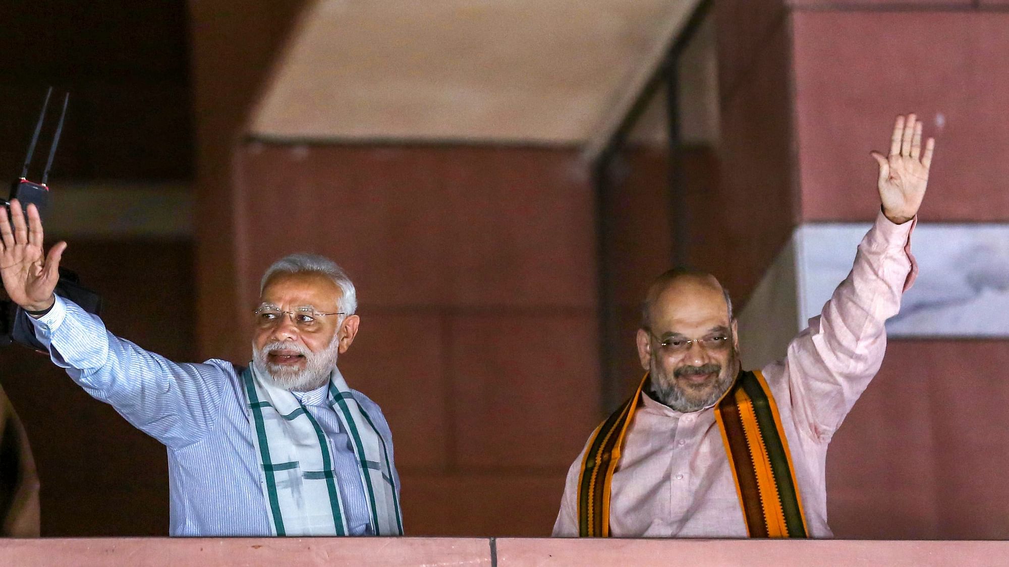 Prime Minister Narendra Modi and BJP president Amit Shah wave at party workers gathered at the BJP headquarters in New Delhi.