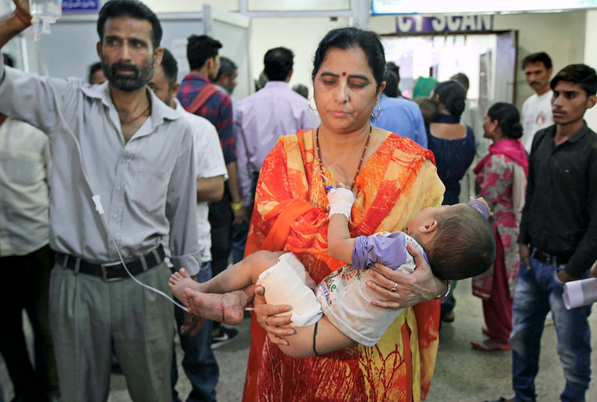 A woman carries her son injured in cross-border firing to a hospital, in Jammu on 23 May
