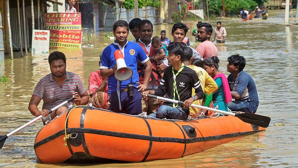 Civil defence personnel rescue villagers on a rubber boat at a flood-affected village after heavy downpour in Agartala on Sunday.&nbsp;