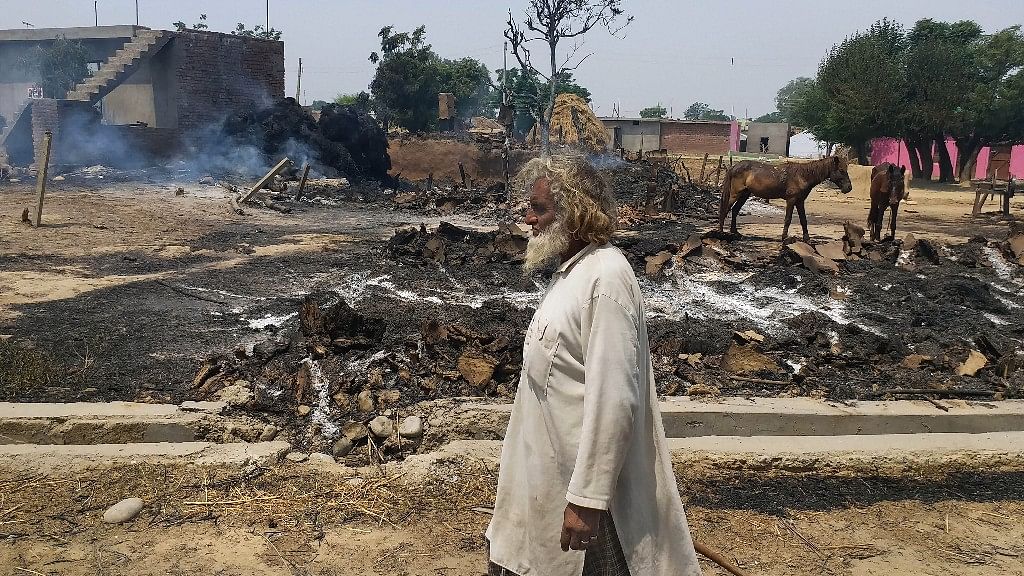 An Indian man inspects the damage after  was gutted by firing allegedly from the Pakistan side of the border.