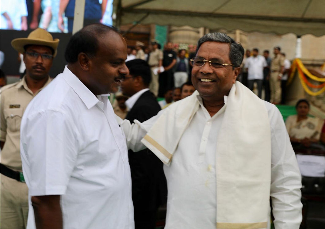 Siddaramaiah gives newly sworn-in Karnataka Chief Minister HD Kumaraswamy a friendly pat.