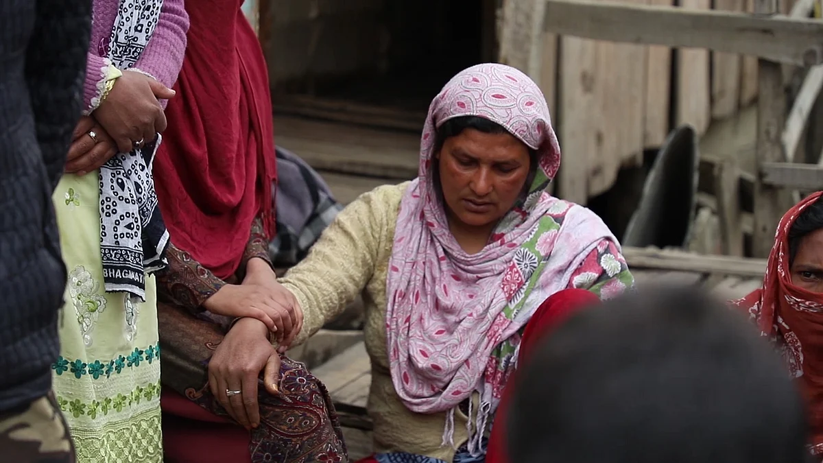 Relatives and neighbours comfort Adil’s mother outside their house in Gasi Mohalla in Srinagar. 