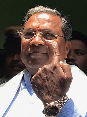 Mysuru: Karnataka Chief Minister Siddaramaiah shows his finger marked with phosphoric ink after casting his vote at a polling booth during Karnataka Assembly Polls at Varuna Assembly Constituency, in Mysuru on May 12, 2018. (Photo: IANS)