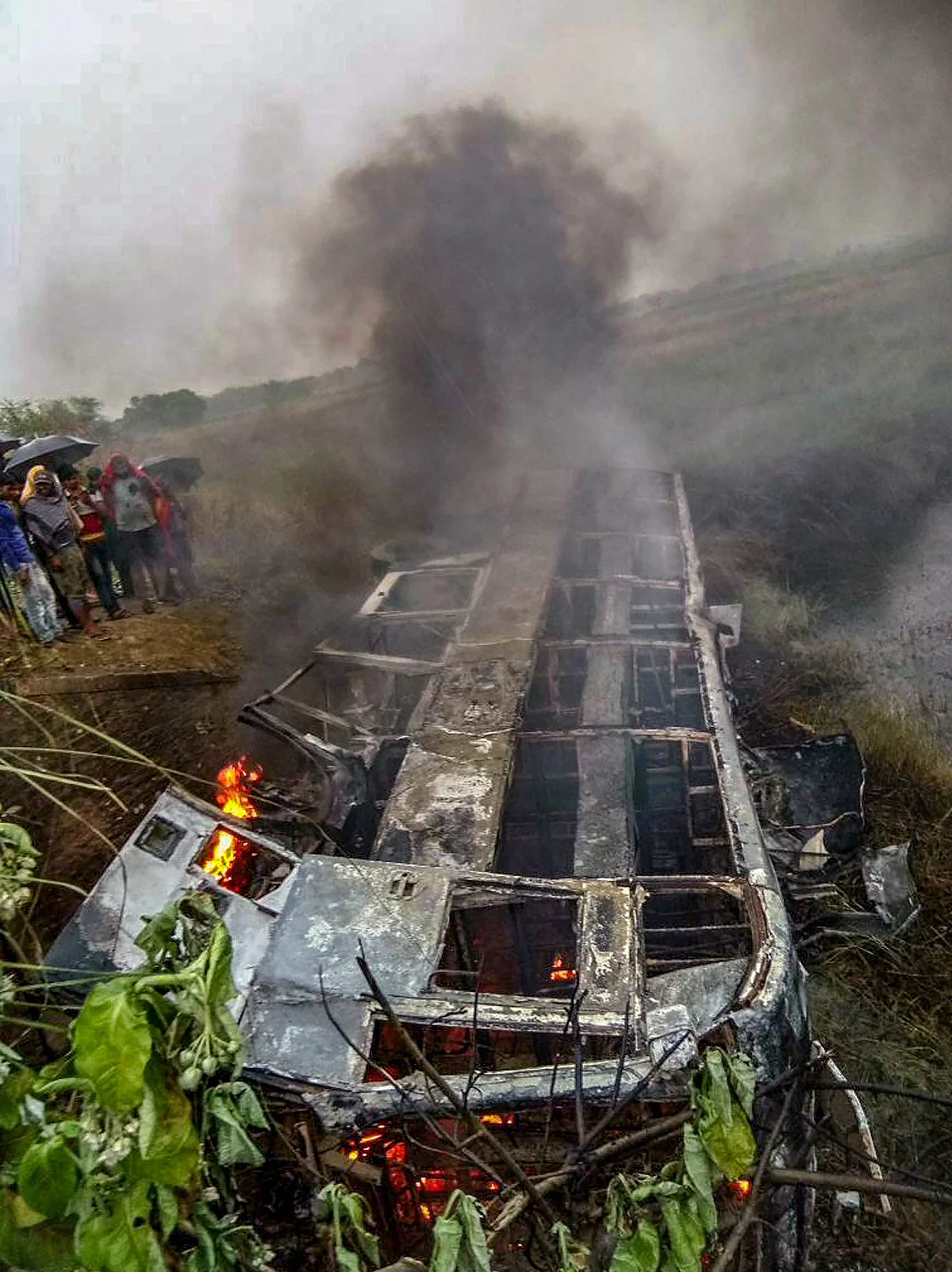 People watch the passenger bus which caught fire claiming two lives in Motihari district of Bihar on Thursday, 3 May.