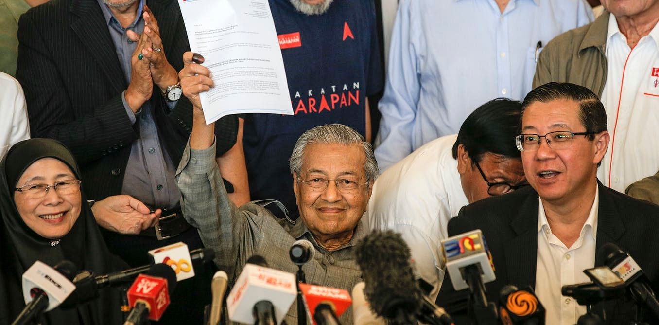 Malaysia’s incoming prime minister, Mahathir Mohamad, waves a letter to the king.