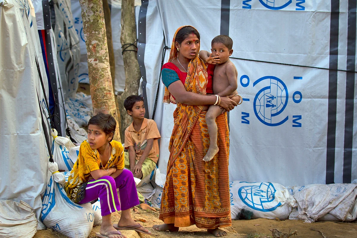In this 16 January 2018, file photo, a Hindu refugee stands outside her makeshift shelter with her children, near Kutupalong refugee camp near Cox’s Bazaar, Bangladesh.
