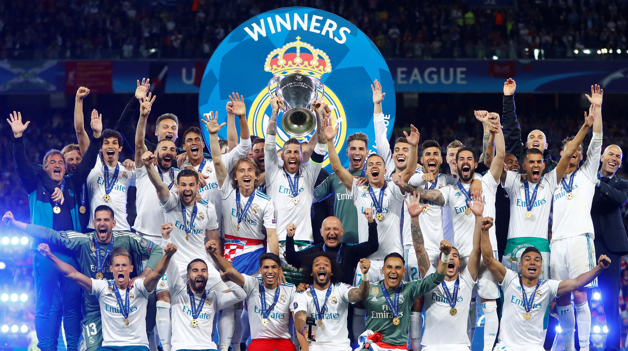 Real Madrid celebrate winning the Champions League with the trophy.