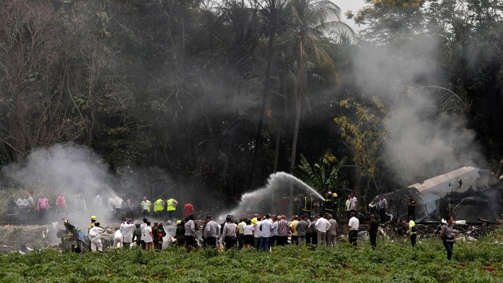 Rescue teams search through the wreckage site of a Boeing 737 that plummeted into a cassava field with more than 100 passengers on board, in Havana, Cuba