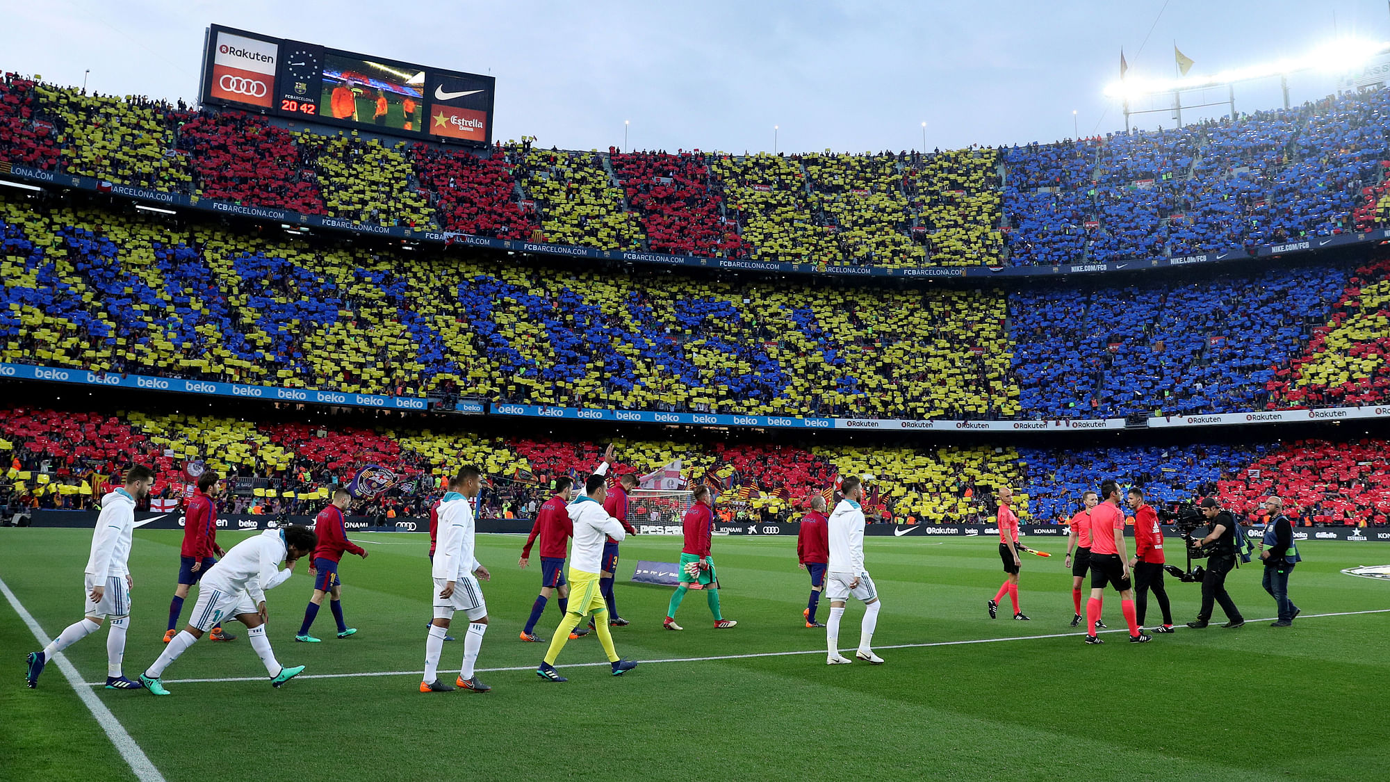 The Real Madrid and Barcelona players enter the field as the fans are ready with their message at Camp Nou.