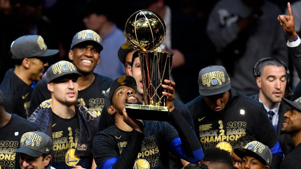 Golden State Warriors forward Kevin Durant (middle) holds the Larry O’Brien Championship Trophy after defeating the Cleveland Cavaliers in game four of the 2018 NBA Finals at Quicken Loans Arena.