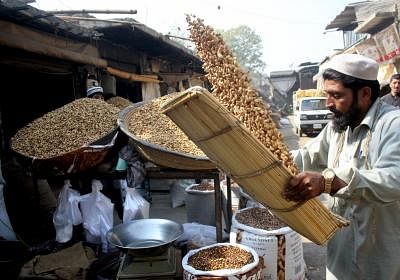 A Pakistani vendor cleans peanuts at a dry fruit market in northwest Pakistan