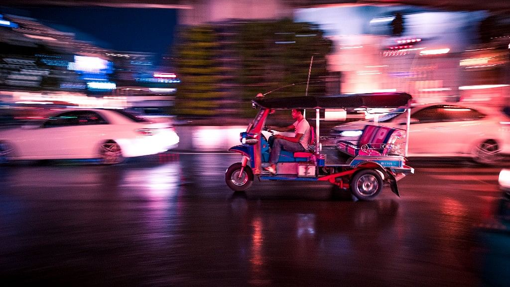 A tuktuk rushing past traffic as the signal turned green.