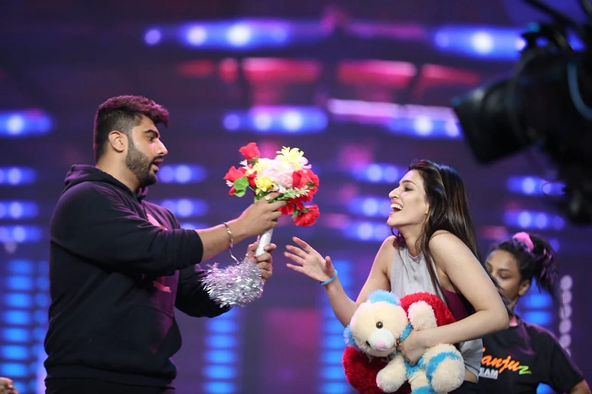 Arjun presents Kriti with flowers and a teddy bear. 