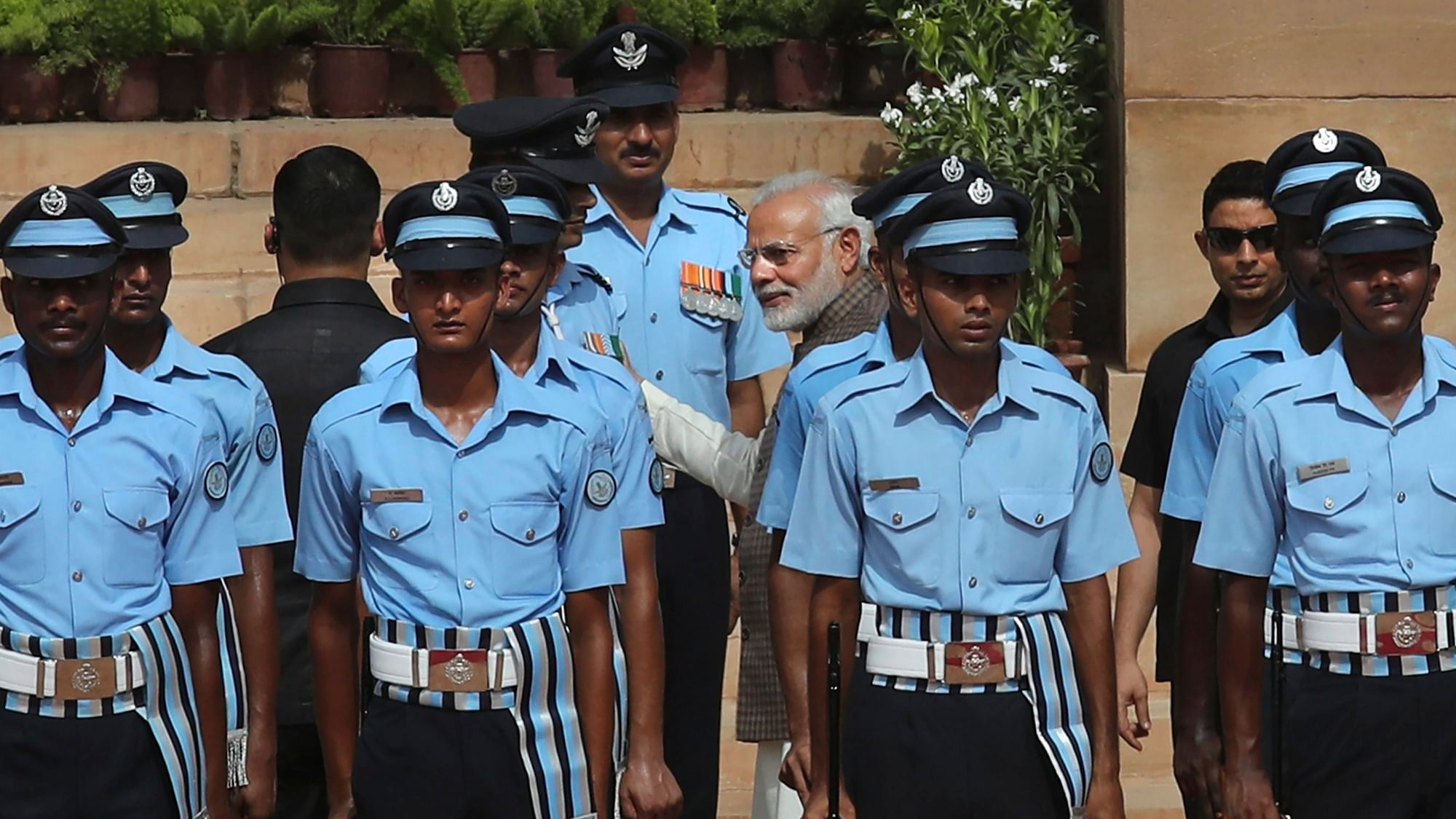 Prime Minister Narendra Modi, centre, talks to an Indian Air Force officer who collapsed while standing to offer guard of honour to visiting Seychelles President Danny Antoine Rollen Faure.