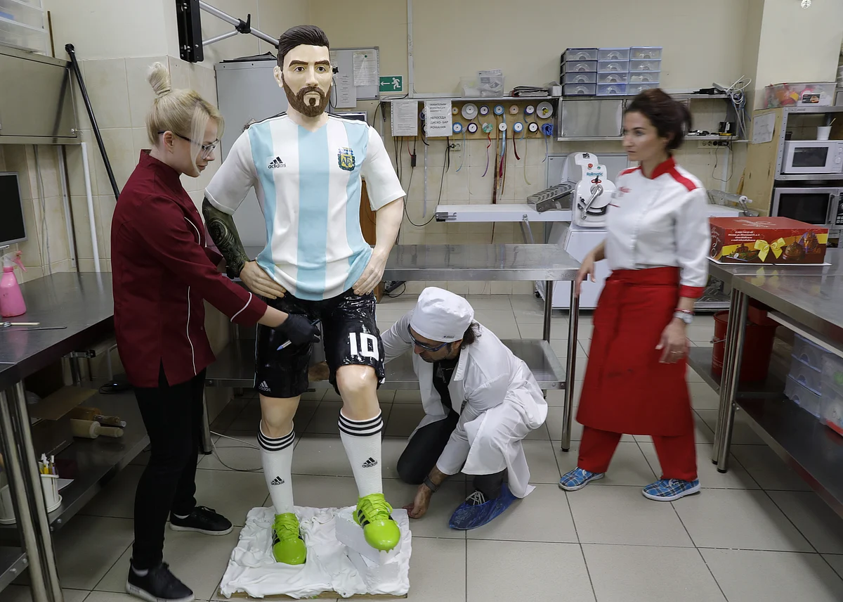 Confectioners working on the chocolate sculpture of Lionel Messi.