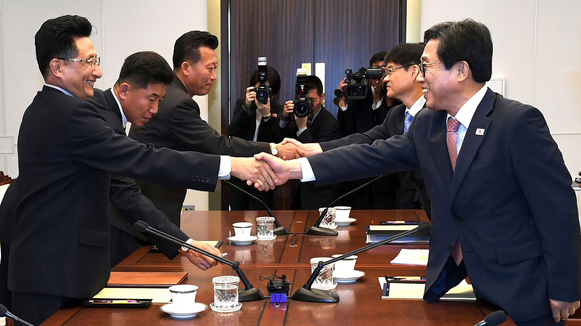 In this photo provided by the South Korea Culture And Sports Ministry, South Korean head delegate Jeon Choong-ryul, right, shakes hands with his North Korean counterpart Won Kil U during a meeting at the southern side of Panmunjom in the Demilitarized Zone, North Korea, Monday, 18 June 2018.&nbsp;