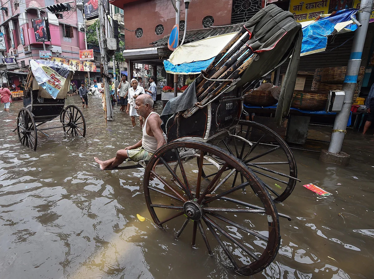A rickshaw puller waits for passengers on a water-logged street after heavy rainfall, in Kolkata on Tuesday, June 26, 2018