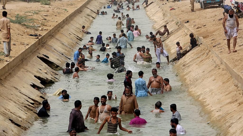 People cool themselves off in a canal as temperature reached 44 C (111 F) in Karachi, Pakistan on 30 May 2018.&nbsp;
