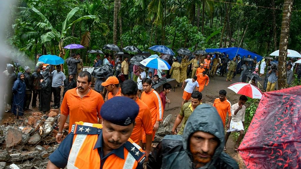 Workers and locals engage in rescue work at a landslide hit area at Kattippara in Kozhikode.