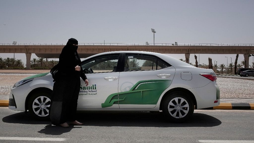 27-year old driving instructor Mabkhoutah al-Mari stands next to a test drivers car at the Saudi Driving School inside Princess Nora University in Saudi Arabia.
