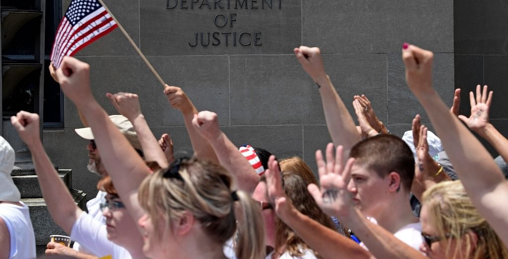 Protesters march past the Justice Department during a rally on immigration in Washington, Thursday, 28 June.