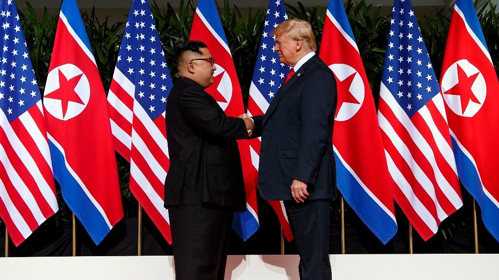 North Korean leader Kim Jong Un, left, and US president Donald Trump shake hands prior to their meeting on Sentosa Island in Singapore on Tuesday, 12 June.